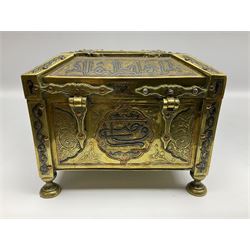Late 19th century Damascus Cairoware Quran box, of square form with canted hinged cover, upon four circular pad feet, the brass exterior inlaid with silver and copper script and decorative detail, opening to reveal a marquetry lined interior, H15.5cm W19cm D19cm