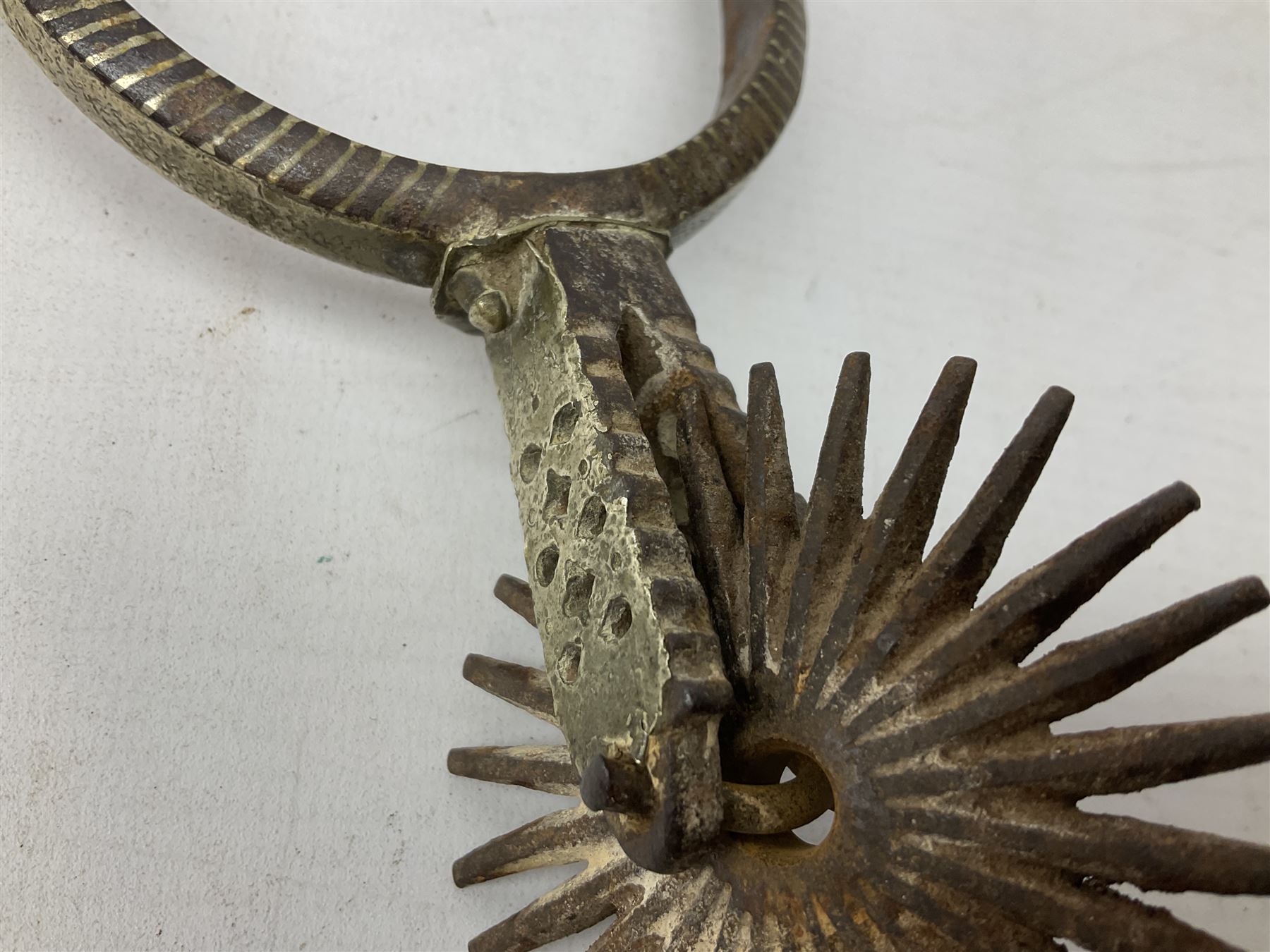 Pair of late 19th century South American iron spurs, engraved silver mounts, with sunburst rowls