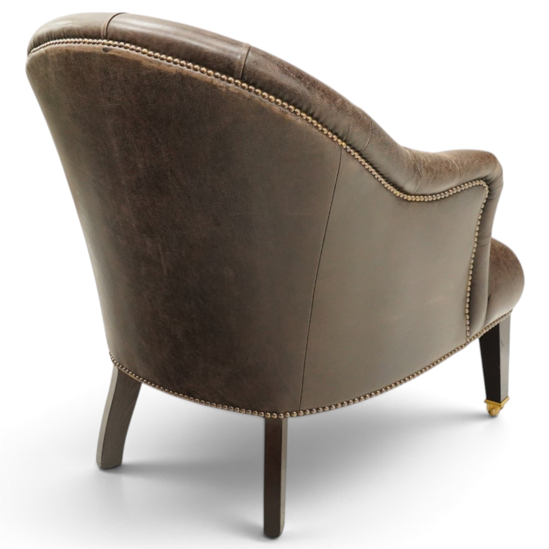 Georgian design tub-shaped club armchair, upholstered in back-buttoned dark tan leather with sprung seat, raised on square tapering supports with brass cups and castors