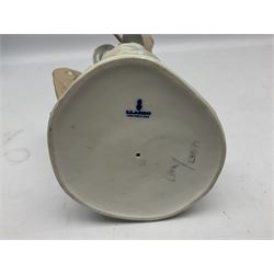 Lladro figure, Violinist, modelled as a man seated upon a  mile stone holding a violin, sculpted by Salvador Furió, no 4887,  year issued 1984, year retired 1981, H35cm