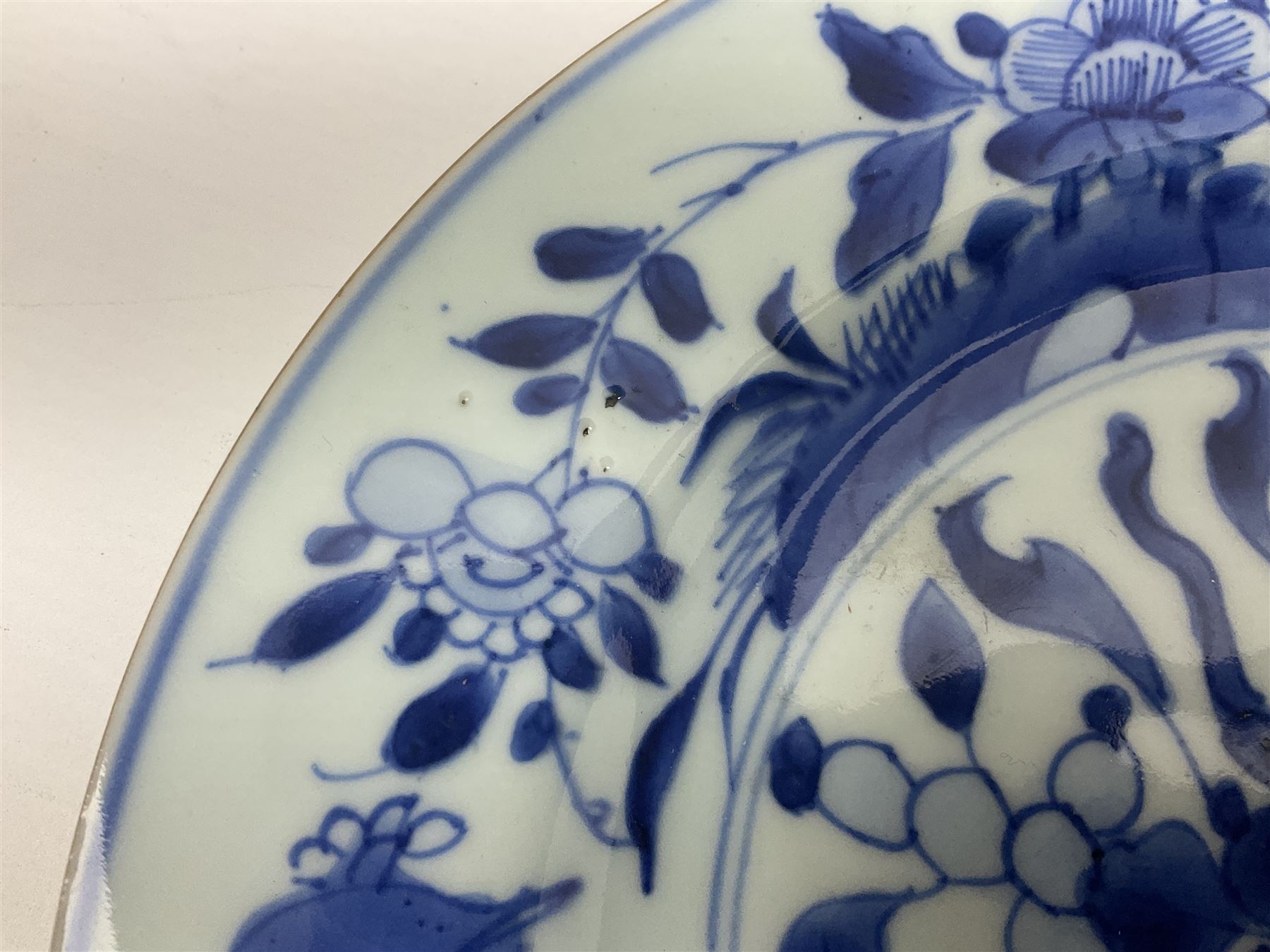 Japanese Meiji period Arita blue and white plate, of circular form, painted with riverside landscape and bird upon flowering branch, with character mark beneath, D24.5cm, together with two 18th century Chinese blue and white plates, each painted with floral design, each approximately D22.5cm