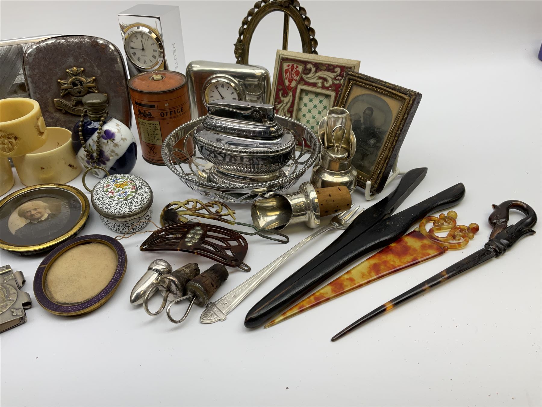 A group of assorted collectables, to include small oval purple guilloche enamel frame, WWII matchbox holder depicting Winston Churchill, Halcyon Days enamel box, Ronson table lighter, ebonised glove stretchers, ivory napkin ring, mother of pearl handled button hook, engine turned cigarette case, etc. 