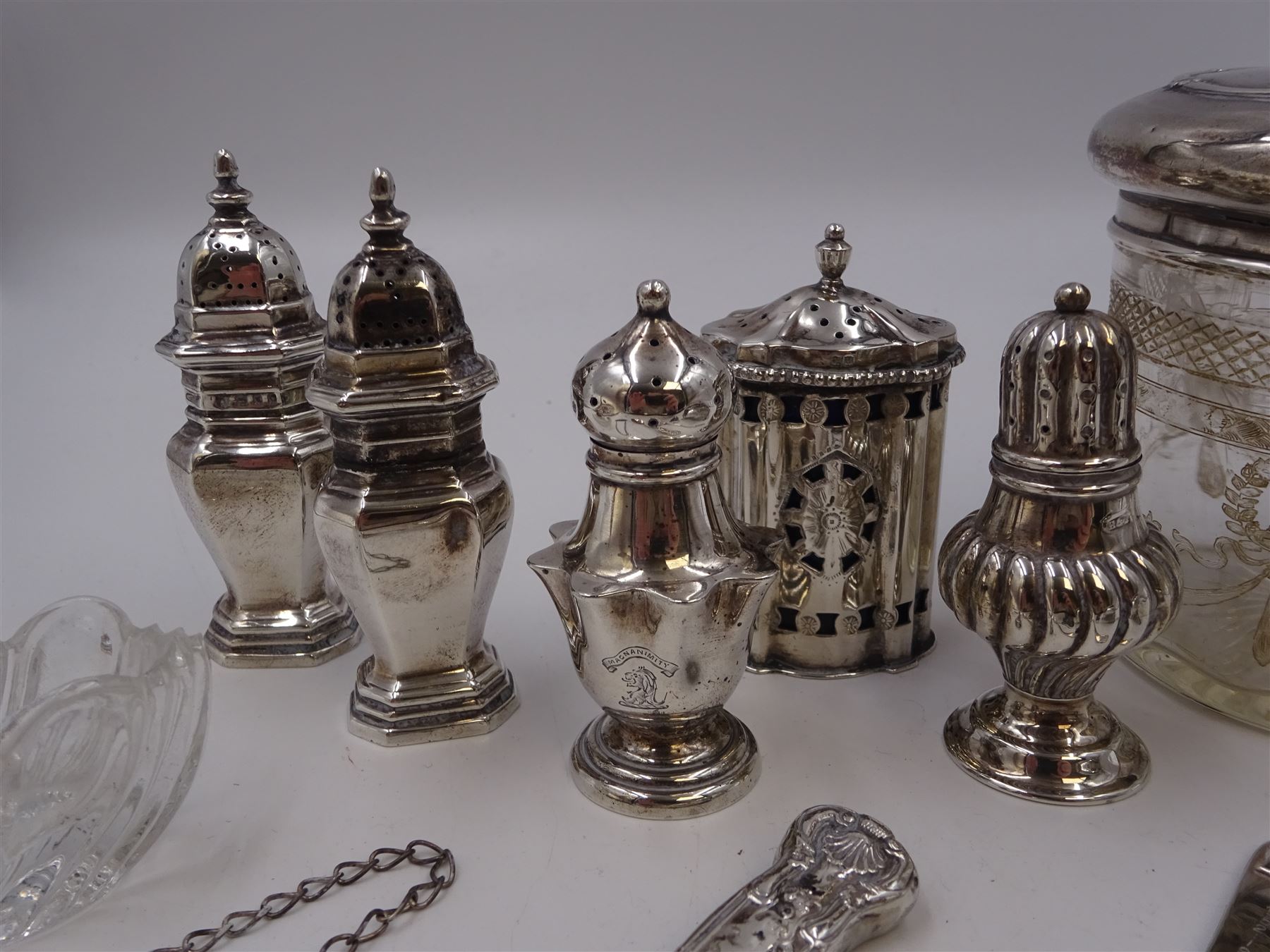 Group of silver, to include Edwardian silver open salt, of circular bellied form, with gadrooned rim, upon three shell feet, hallmarked Mappin & Webb Ltd, London 1906, together with a blank decanter label, repousse decorated with fruiting vines, hallmarked W I Broadway & Co, Birmingham 1995 and five silver pepper shakers, all hallmarked with various dates and makers, etc 