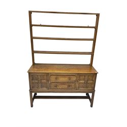 Early 20th century oak dresser, four tier plate rack over two panelled cupboards and two drawers 