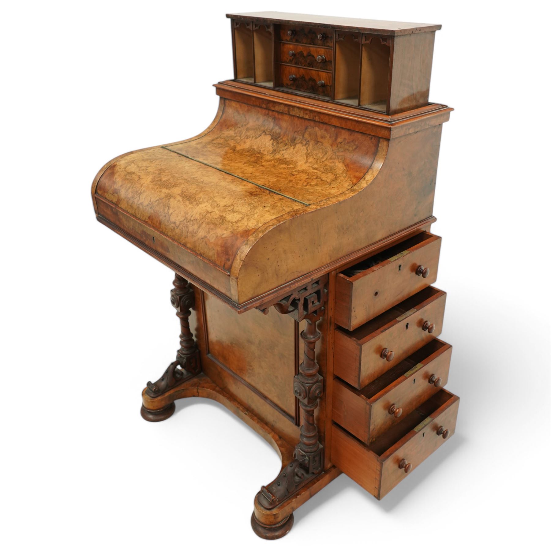 Victorian figured walnut piano top Davenport desk, hidden compartment lifting to reveal small drawers and pigeonholes, the piano lid enclosing drawers and sliding top with hinged leather writing surface, the right-hand side fitted with four drawers, on compressed bun feet 