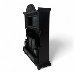 Early 20th century Japanese Meiji style carved hardwood cabinet, of symmetrical tiered form with pierced foliate fretwork panels and phoenix crest, fitted with sliding and hinged doors inset with hand-painted landscape panels depicting Mount Fuji, waterfalls, and lakeside dwellings, raised on shaped bracket supports