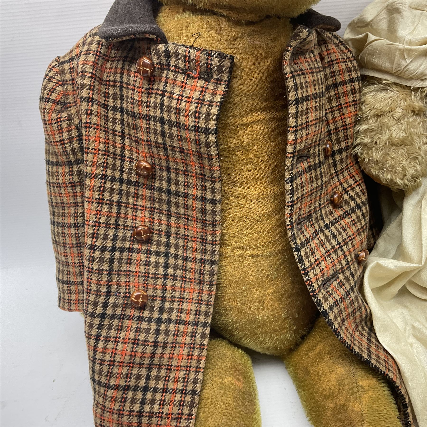 Two early 20th century straw filled jointed teddy bears, first example wearing a tweed jacket bearing Geoffrey Saville label, with leather padded paws and ears, horizontally stitched nose and humpback; second example with applied eyes, vertically stitched nose and faux leather paw pads, both with growler mechanisms, tallest H74cm 