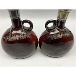 Pair of Victorian brown glass spirit decanters, each with ring handle and silver plated lid and scallop shell thumb piece, (one lacking stopper) H22cm, together with three 19th century decanters with twisted handles, comprising two blue examples and one green, together with four sprit labels
