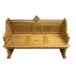 Carved teak garden bench, the cresting rail carved and pierced with foliate design, shaped arms and end supports decorated with scrolling foliage and flower heads