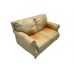 Two seat sofa, upholstered in pale tan leather with scrolled arms