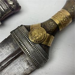 Eastern Jambiya, the 20cm double edge steel blade with raised medial ridge, waisted grip with pique work; in leather scabbard with jewelled white metal decoration 