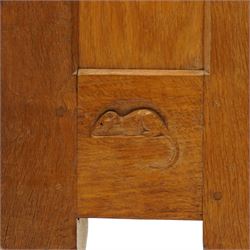 Mouseman - 1940's adzed and panelled oak corner cupboard, the raised quarter-gallery back over twin adzed panelled doors with wrought iron fittings and latch, enclosing three shaped shelves, raised on turned octagonal supports, with carved mouse signature in relief, by the workshop of Robert Thompson of Kilburn Provenance: purchased directly from the Kilburn workshop in the late 1940s
