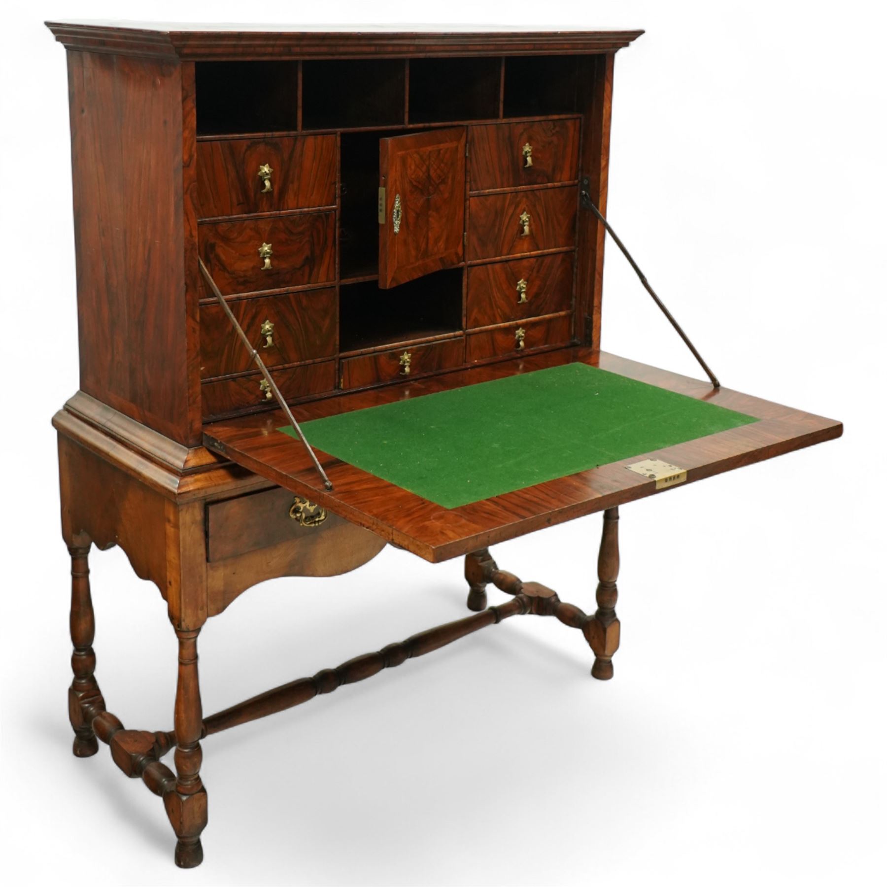 Early 18th-century George I walnut bureau cabinet on later stand, moulded rectangular cornice above fall front, inlaid oval burr walnut panel opening to reveal a fitted interior of drawers, pigeon holes, and a central cupboard door, with baize-lined writing surface above a long drawer over a shaped apron and turned legs joined by a turned stretcher, lacks key, later brass strut supports