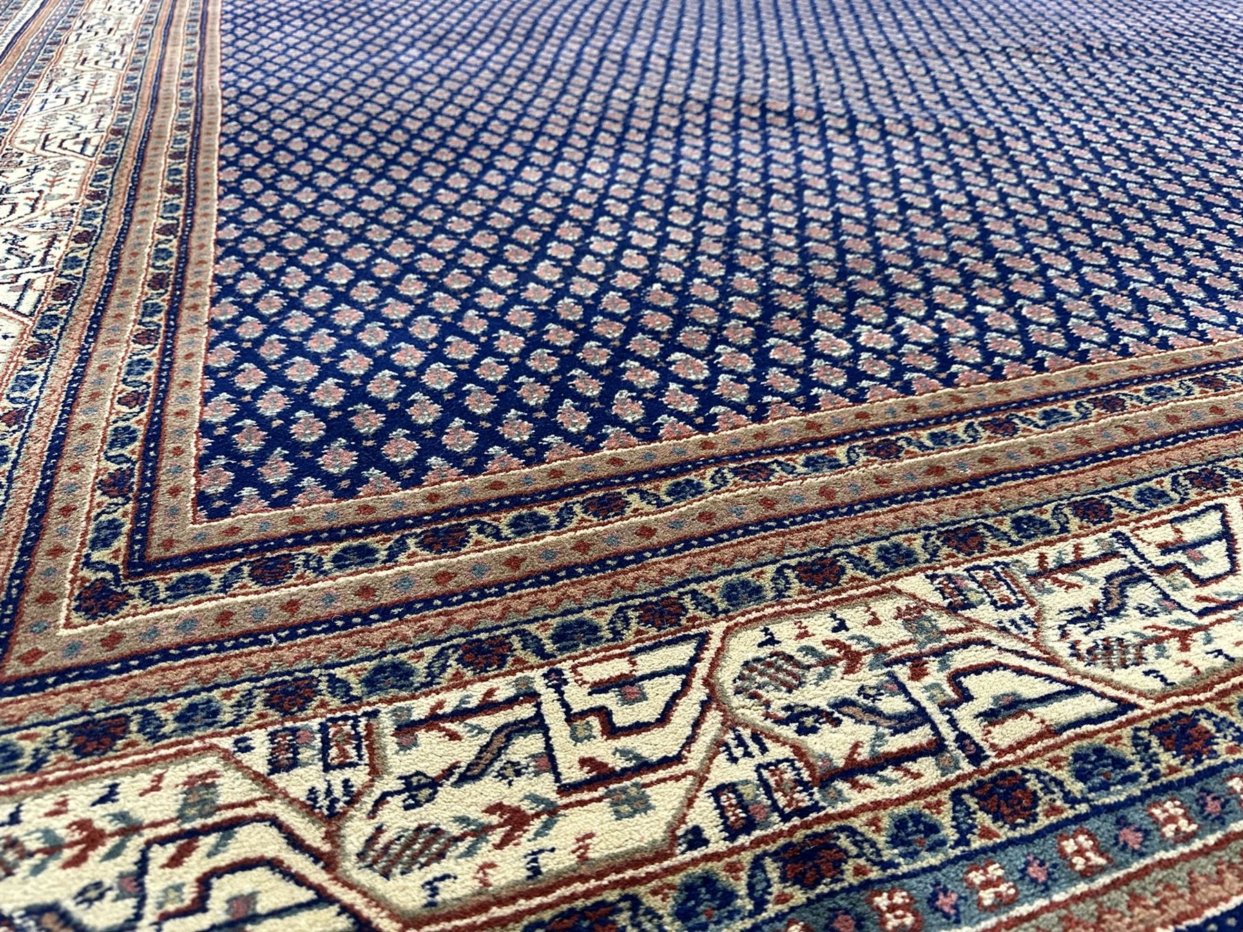 Large North-West Persian Arrak indigo ground carpet, the field decorated all-over with small Boteh motifs, multiple band border decorated with repeating geometric designs 