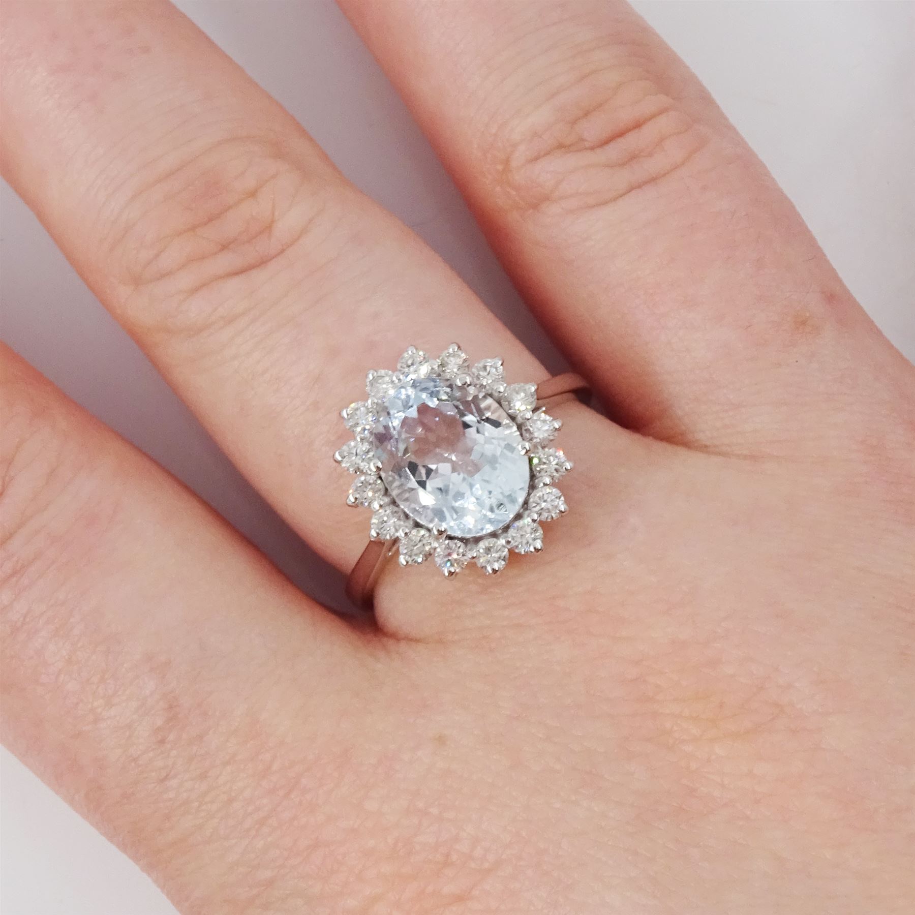 18ct white gold aquamarine and diamond cluster ring, single oval cut aquamarine of approx 2.25 carat, surrounded by sixteen round brilliant cut diamonds, stamped 18K, total diamond weight approx 0.50 carat
