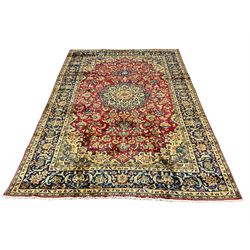 Persian Najafabad red ground carpet, large central medallion in a field of interlaced foliate, scrolling guarded border, decorated all over with stylised flower and plant motifs 