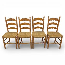 Late 20th century pine farmhouse dining table and four chairs, the rectangular plank top with rounded corners over two frieze drawers fitted with turned knob handles, raised on turned legs, the chairs with shaped ladder backs and turned finials, rush seats in a herringbone weave, on turned supports united by stretchers