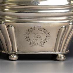 Edwardian silver teapot, of part fluted oval form upon four bun feet, with ebonised handle and finial and presentation engraving to body, hallmarked Thomas Bradbury & Sons, London 1904, H17cm