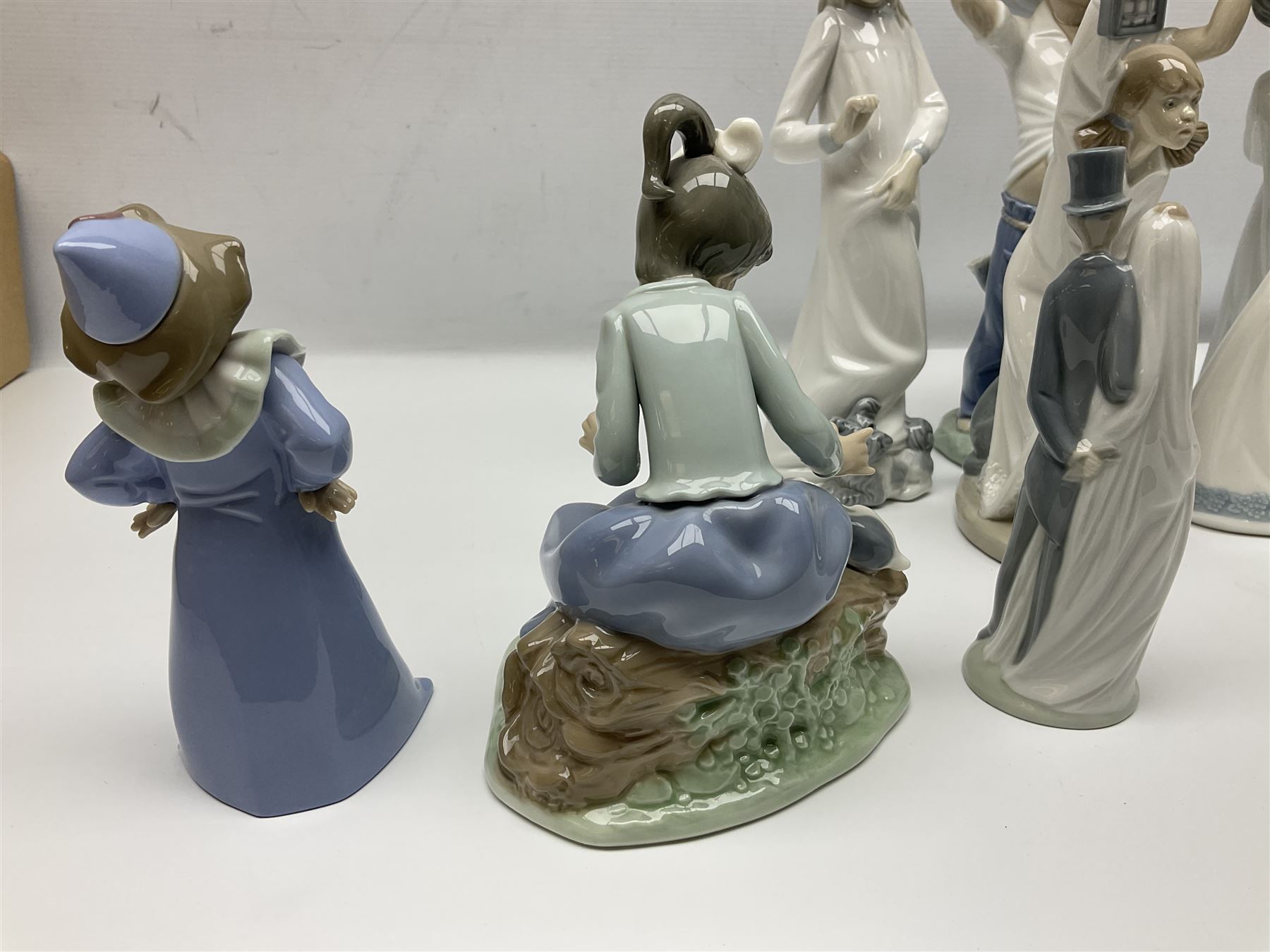 Eleven Nao figures to include Cowboy, Girl with Puppy, Clown, Girl in hat etc 