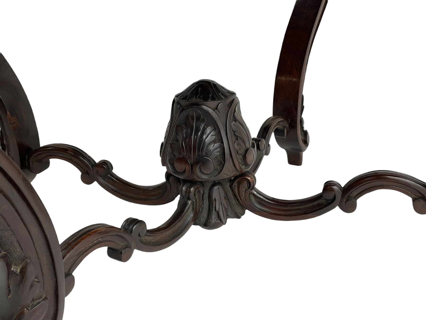 19th century Irish rosewood centre table, the shaped and moulded top over shaped apron carved with scrolled foliage, on serpentine supports carved with bell flowers, the supports united by anthemion carved finial and s-scroll x-framed stretchers