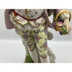 Large pair of late 19th century Continental figures in the Meissen style, modelled as a gardener and companion in 18th century dress, holding baskets of flowers and posies, each upon naturalistically modelled floral encrusted square base with scroll moulded sides, with underglaze blue cross sword type marks beneath, tallest example H49cm