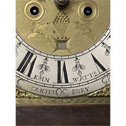 John Watts of Canterbury - early 18th century 8-day oak longcase clock, with a flat topped hood, broad cornice, dentil moulding and blind fret beneath, baluster turned pilasters with wooden capitals flanking the square hood door, trunk with recessed beaded edge and a long ogee topped door with crossbanding, plinth with applied skirting, square brass dial with matching steel hands, cast spandrels and a matted and engraved centre, date aperture, seconds ring and ring turned winding apertures, silvered chapter ring with Roman numerals, five minute Arabics, minute and quarter hour tracks, five pillar movement with a recoil anchor escapement and inside countwheel strike, sounding the hours on a bell. With weights and pendulum.