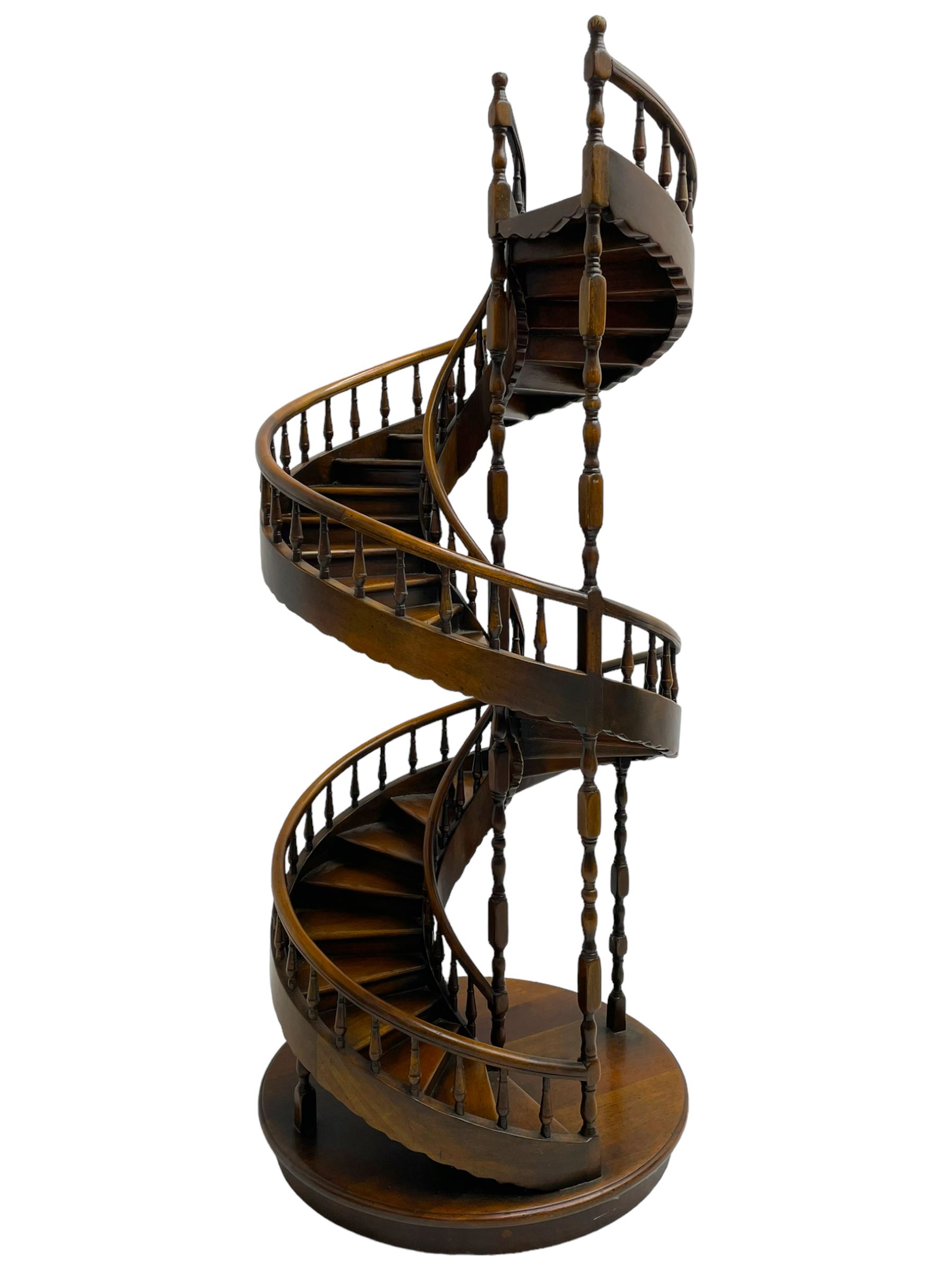 Miniature fruitwood spiral staircase, turned newel posts and balusters, rounded handrail, on circular moulded base
