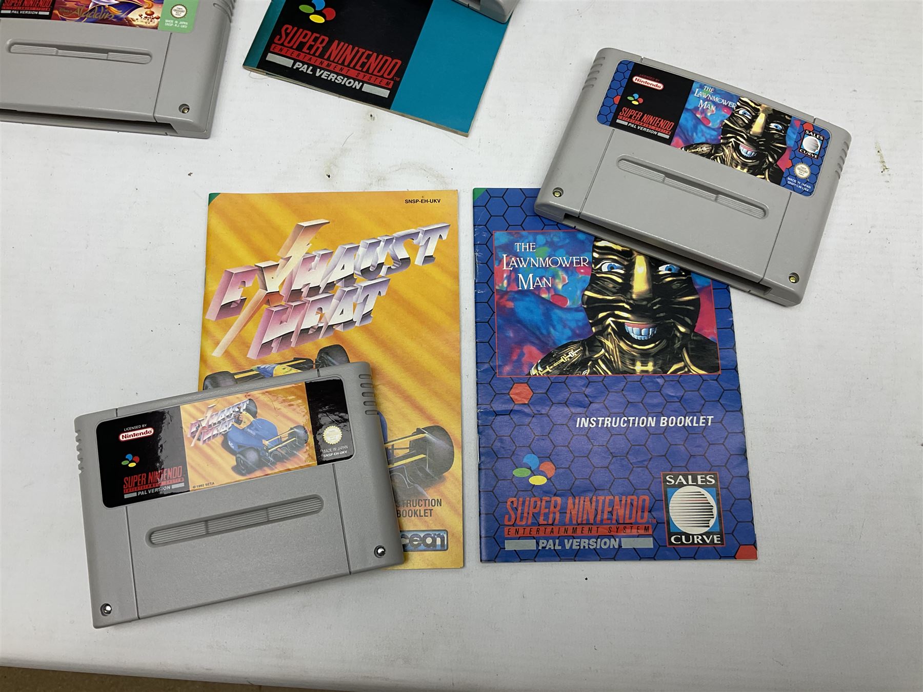 Two Super Nintendo Entertainment System (PAL) controllers, accessories and games. Super NES Game Commander with original box and instruction booklet, Super NES Nintendo Scope (1992) transmitter gun, receiver, Super NES Nintendo Scope 6 game with original instruction booklets. Further games to include ‘The Legend of Zelda a Link to the Past’, ‘Super Mario World’, ‘Super Mario Kart’, ‘The Lawnmower Man’, and ‘Exhaust Heat’, all with original instruction booklets. ‘PowerMonger’ and Disney’s ‘Aladdin’ game cartridges only 