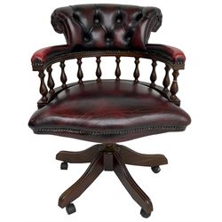 Georgian design swivel desk chair, the rolled back over balustrade support, upholstered in buttoned oxblood leather with studwork border, over a swivel and reclining action with splayed supports and castors