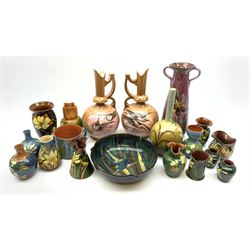 Collection of Devon pottery all having floral slip decoration and include Aller Vale, Watcombe, possibly some Longpark, and other unmarked pieces, tallest H25cm together with a pair of T. Forester jugs hand-painted with cranes and two further Devon pottery pieces, both hand-plated with birds 