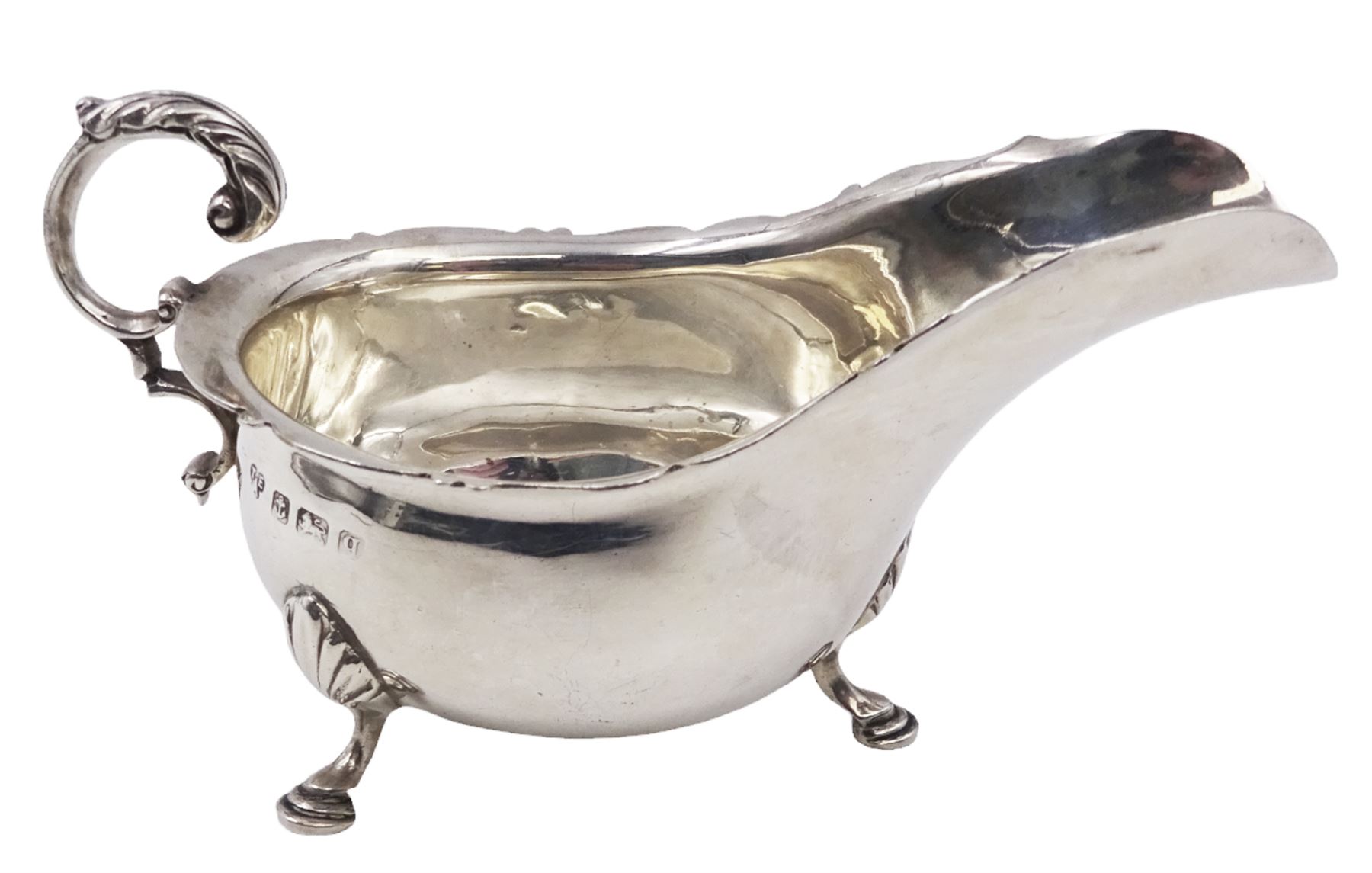 Early 20th century silver sauce boat, of typical form with shaped rim and acanthus capped flying C scroll handle, upon three palmette mounted hoof feet, hallmarked Thomas Edward Atkins, Birmingham 1915, including handle H8.5cm