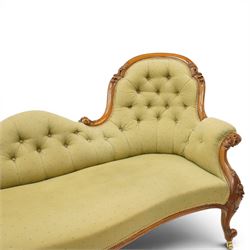 Victorian mahogany framed double ended chaise longue, serpentine button upholstered back with raised scrolled ends, padded arms and stuff-over seat upholstered in green fabric, carved showframe with foliate terminals and scroll supports, on short cabriole legs with brass castors