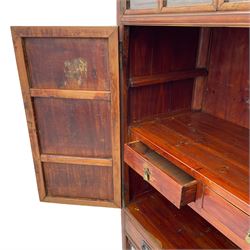 Late 19th century Chinese Qing dynasty red and black lacquered wood cabinet,  Fujianese province, upper cupboard enclosed by two doors with relief carved and gilt panels depicting figures behind glass, the large cupboard enclosed by two panelled doors carved with trailing foliate branches and birds, inscribed with Chinese characters, to the left ‘The red mountains are in the shape of Phoenixes and appear auspicious’ and to the right, ‘Wealth and honour are given by flowers and I hear the sound of the phoenix', fitted with two drawers, on square supports with carved brackets 