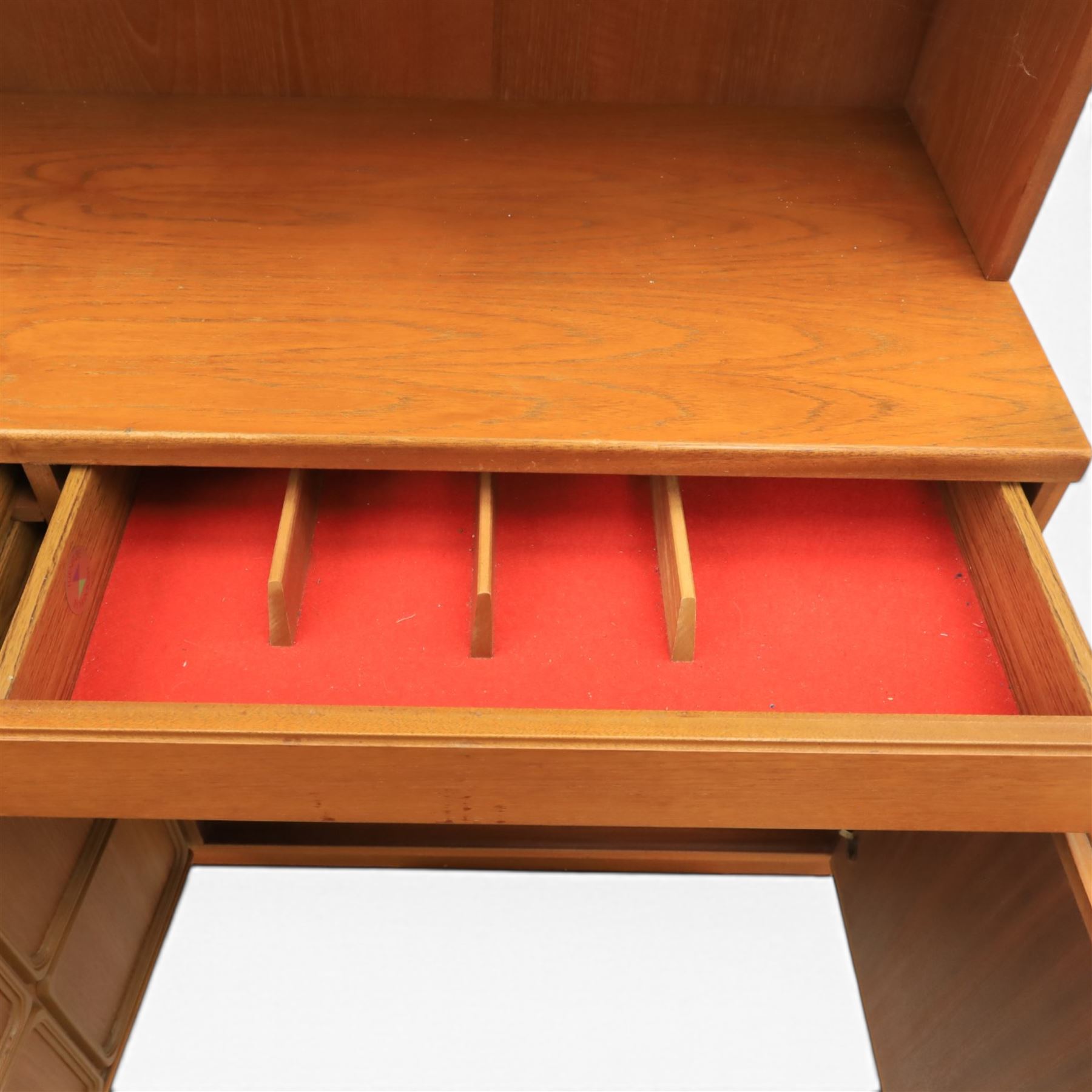 Mid-20th century teak wall display unit, featuring two glazed cupboards and fall front compartment with open shelves, above three drawers and cupboards to the base