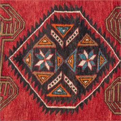 North East Persian Kurdie runner, the red field decorated with three serrated diamond medallions alternating with four ochre hooked motifs enclosing polychrome cruciform panels, within multiple geometric borders of repeating triangles and diamond devices