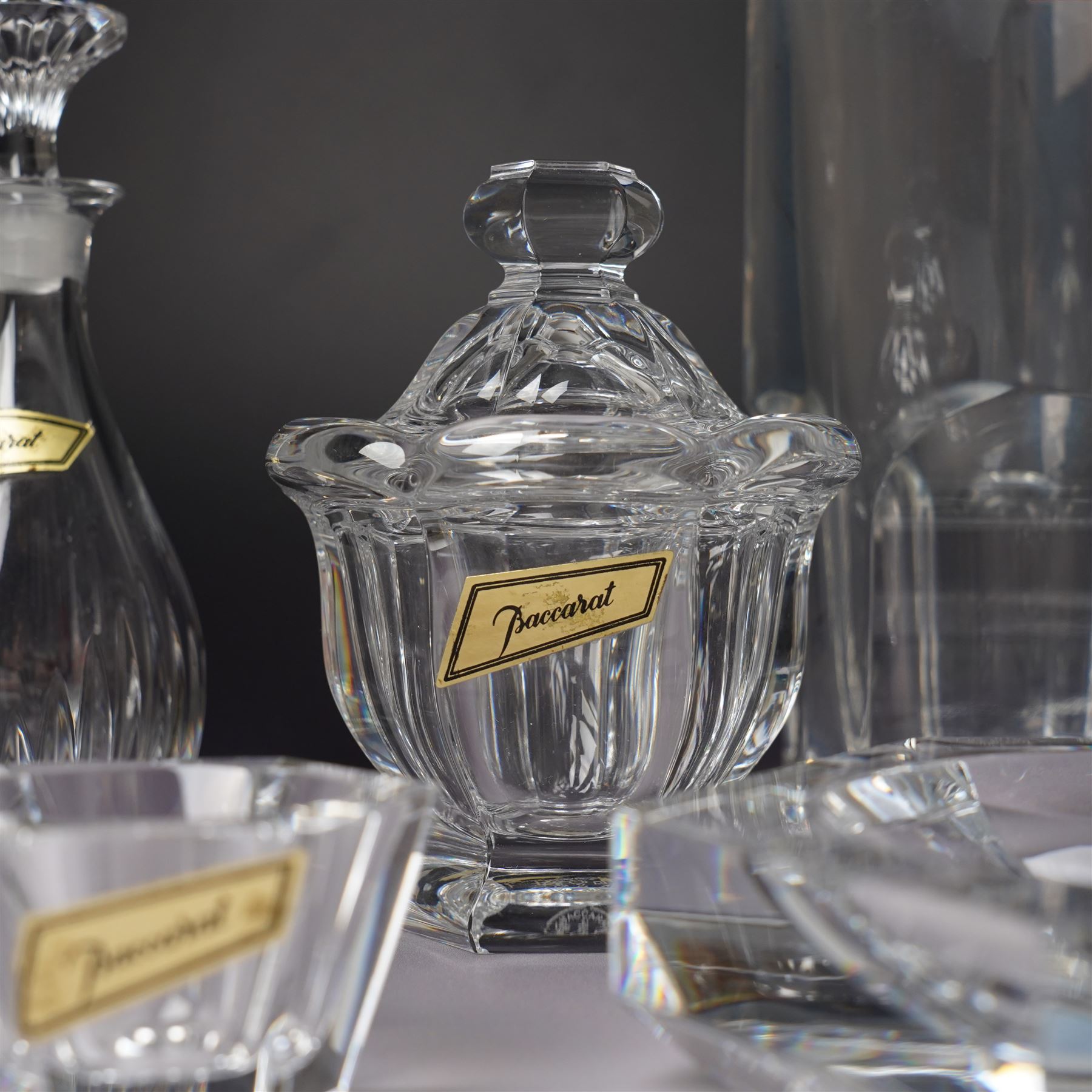 Collection of Baccarat Crystal, comprising a 'Pluton' decanter and two smaller examples, two covered condiment jars, pair of salt cellars, and an ashtray, variously boxed