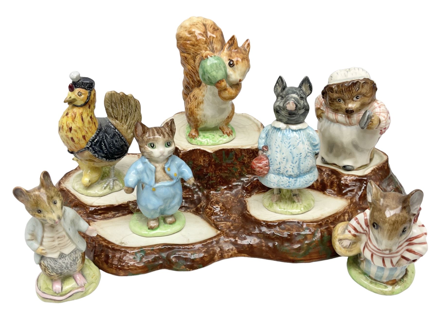 Seven Beswick Beatrix Potter figures, comprising Sally Henny Penny, Johnny Town-Mouse, Mrs Tiggy-Winkle, Mrs Tittlemouse, Tom Kitten, Pig-Wig and Squirrel Nutkin, together with a Beswick tree trunk display stand, stand L30cm