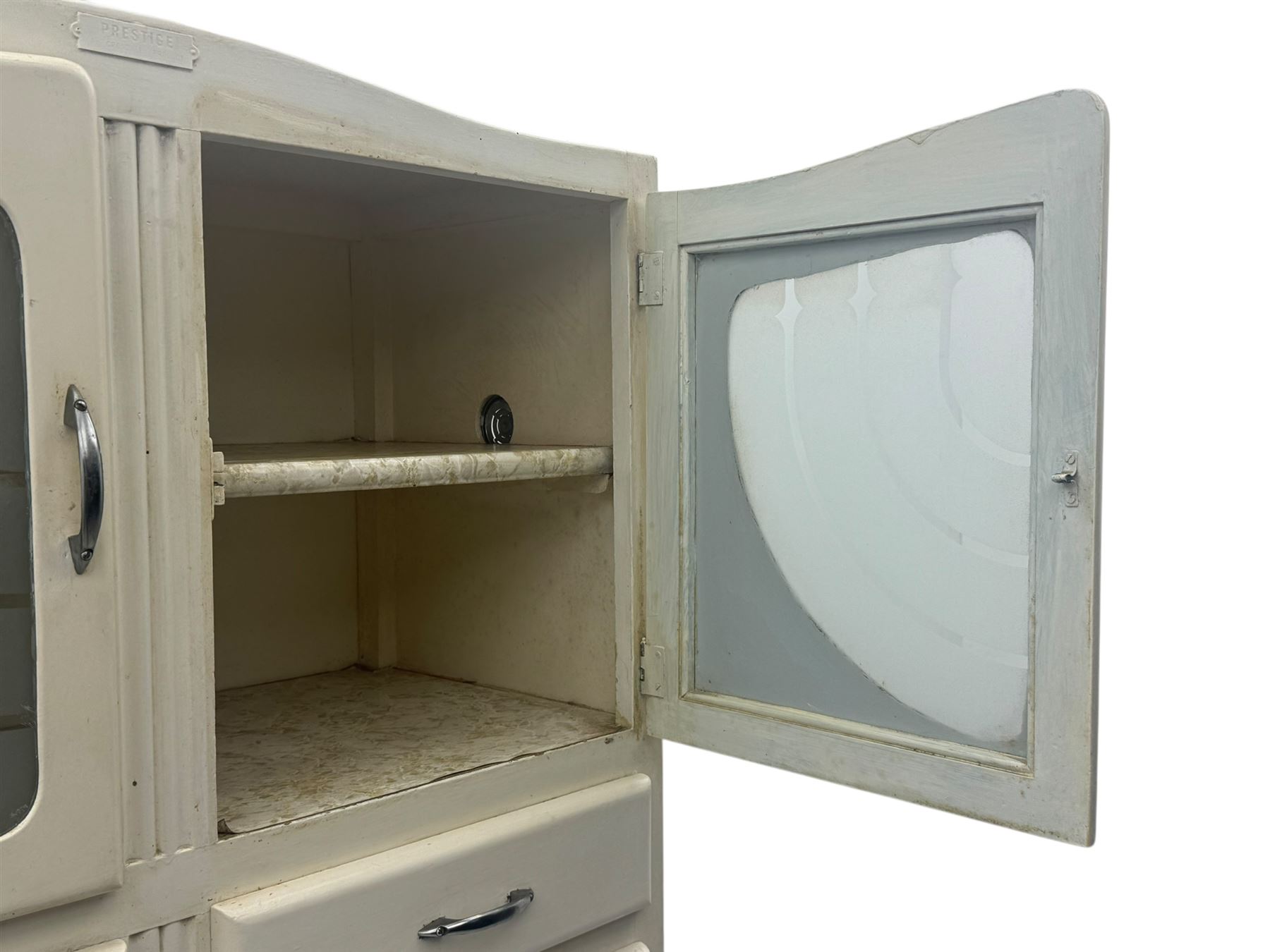 Mid-20th century painted kitchen cabinet, moulded top above a pair of glazed cupboard doors with stylised arrow motif panels, over two drawers and a fall-front cupboard, the lower section with twin cupboard doors
