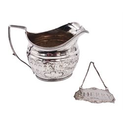 George III silver cream jug, of helmet form with angular handle, embossed with floral and scrolling decoration and engraved initial, hallmarked Edward Mayfield, London 1806, H9.3cm, together with a modern silver 'Sherry' decanter label, hallmarked Birmingham Mint, Birmingham 1986