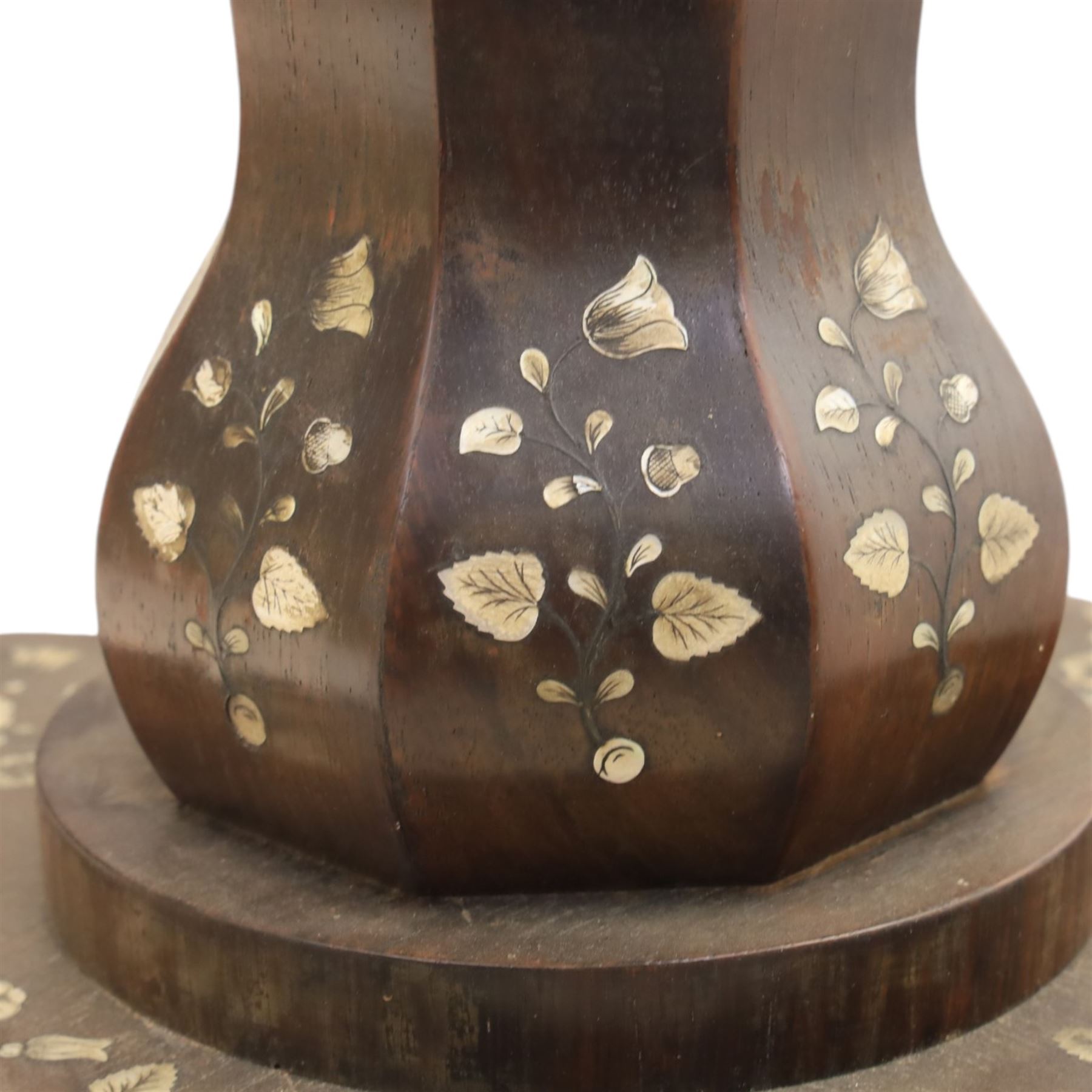 Victorian mahogany and mother-of-pearl inlaid work table, the octagonal hinged top enclosing a mirror and fitted compartmented interior, raised on a carved pedestal and quatriform platform base with scrolled feet