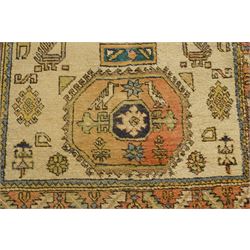 Two Caucasian designed rugs comprising a flatweave and hand-knotted rug, Caucasian design flatweave, cream ground with three large blue geometric medallions surrounded by stylised birds and geometric motifs, enclosed by repeating geometric border, fringed ends, H176cm, W102cm; hand-knotted Caucasian rug, ivory ground with three polychrome octagonal medallions surrounded by stylised animals, flowerheads and geometric motifs, enclosed by salmon pink geometric border, fringed ends, H163cm, W106cm