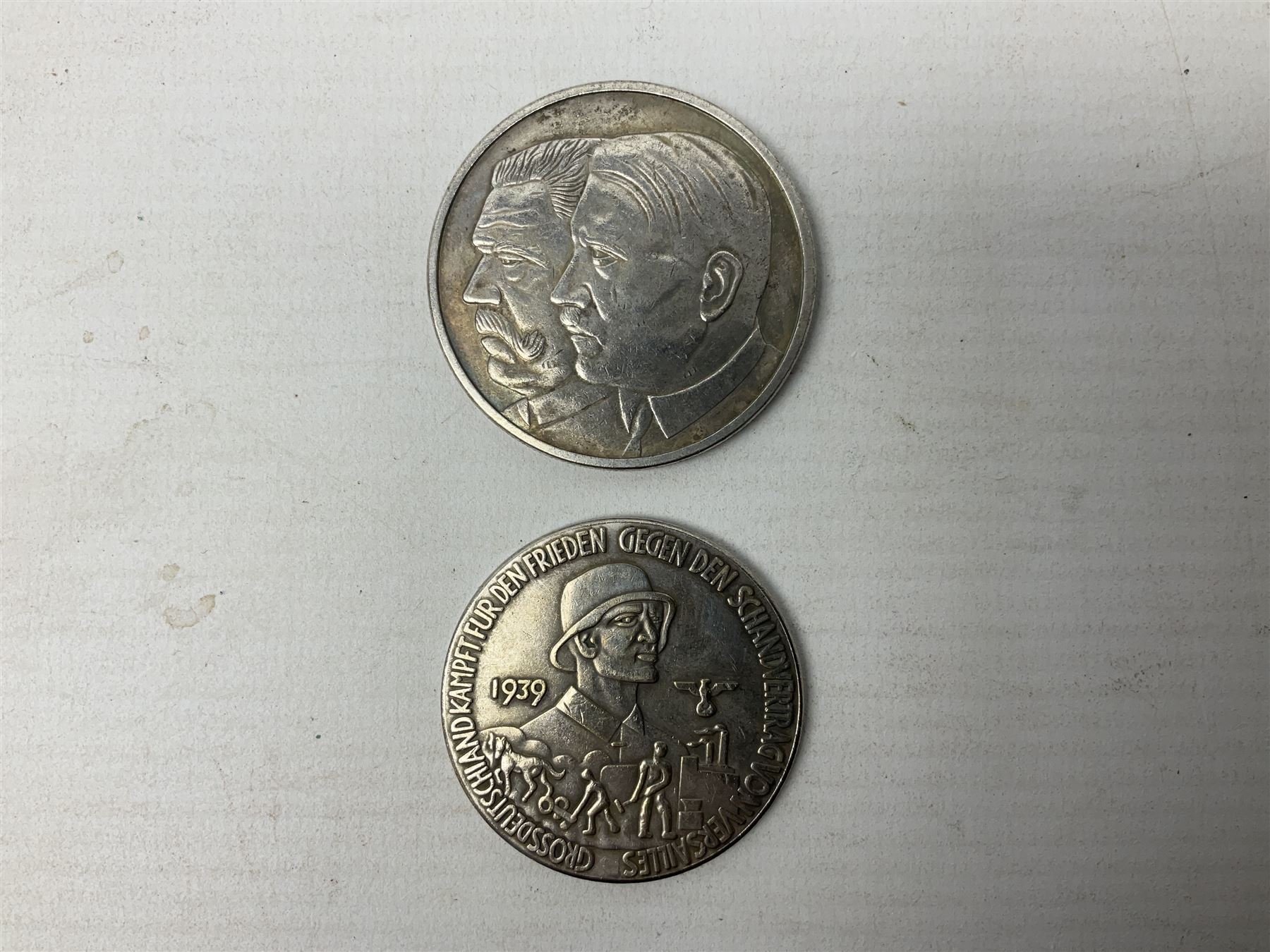 Four post-WW2 'silver' medallions of Adolf Hitler/German interest, two depicting Von Hindenburg also; and pair of 1960s trench art shell case bases as ashtrays mounted with Libyan Five Milliemes coins as cigarette rests (6)
