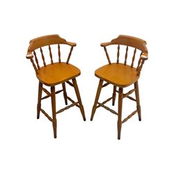 Pair of late 20th century beech bar stools, with curved top rail and turned spindle back, shaped seat over four turned legs united by multiple stretchers