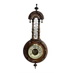 German- Late 19th century aneroid Barometer in a carved mahogany case with pendants and finials, 4” open dial register and mercury thermometer, with another early Edwardian aneroid barometer in a circular carved  walnut case with a 4