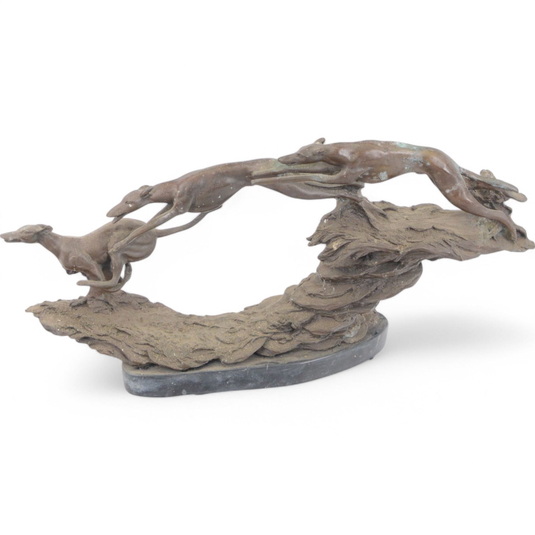 Bronzed sculpture of three greyhounds running at speed, on naturalistic base and oval plinth, L54cm H26cm 