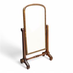 Early 19th century mahogany cheval dressing mirror, plain mirror plate within chamfered frame with arched top, on rolled horns and out-splayed rolled feet, united by turned stretcher 