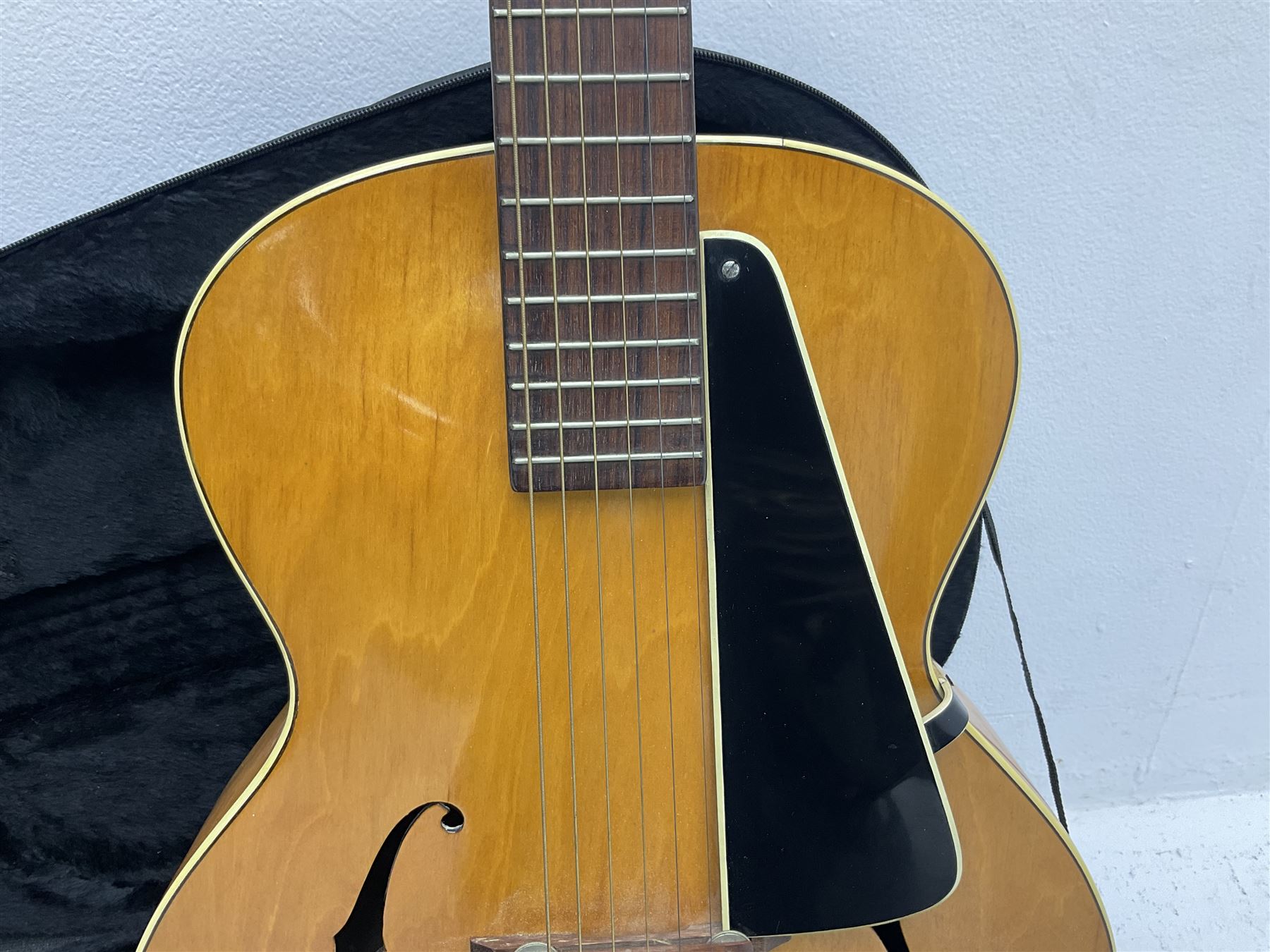 1950s acoustic guitar with f-holes and pickguard L105cm; black fur lined hard carrying case