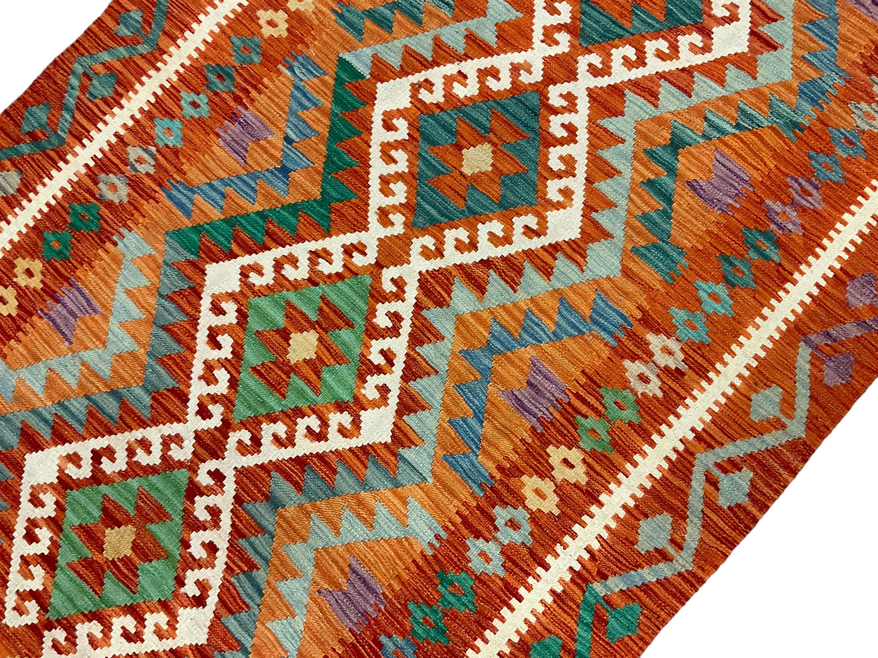 Anatolian Turkish Kilim amber ground rug, the field decorated with four lozenges with ivory outline, the double banded orange border with repeating geometric patterns 
