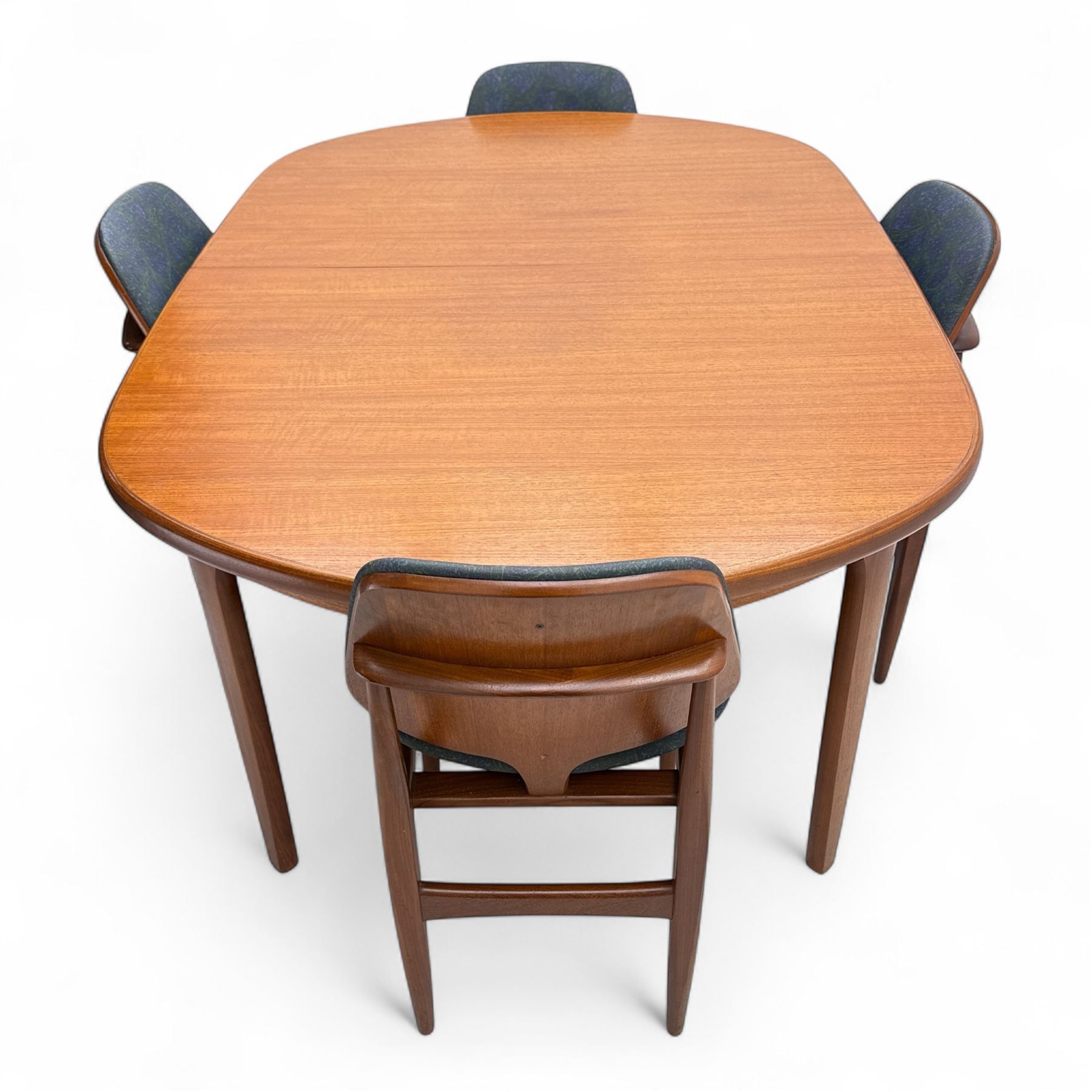 G-Plan - mid-20th century teak oval dining table, with butterfly leaf extension mechanism and four Elliot's of Newbury teak framed dining chairs upholstered in purple and green fabric, table un-extended width 152cm x depth 152cm x height 71cm, chairs 47x37x78cm 