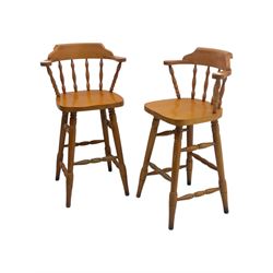 Pair of late 20th century beech bar stools, with curved top rail and turned spindle back, shaped seat over four turned legs united by multiple stretchers